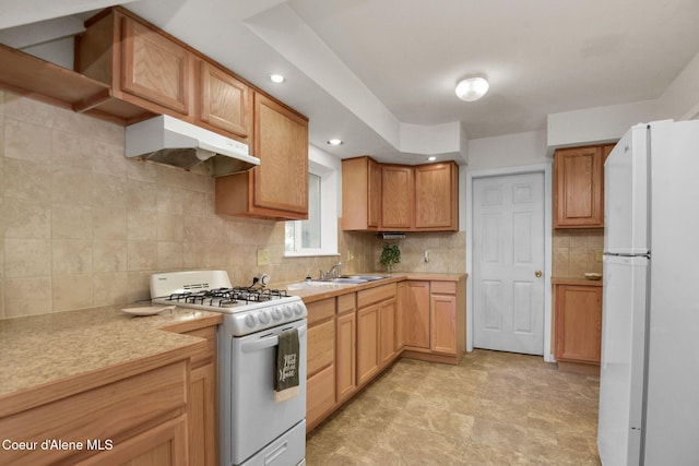 694 S Signal Point Rd, Post Falls, ID 83854 - kitchen with white appliances, under cabinet range hood, light countertops, tasteful backsplash, and recessed lighting
