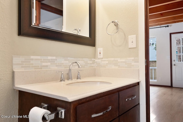 bathroom featuring decorative backsplash, wood-type flooring, and vanity