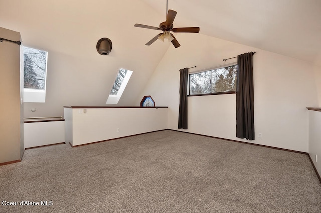 unfurnished living room with carpet floors, lofted ceiling with skylight, and ceiling fan