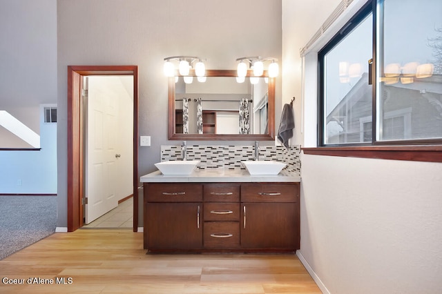 bathroom with decorative backsplash, wood-type flooring, and vanity