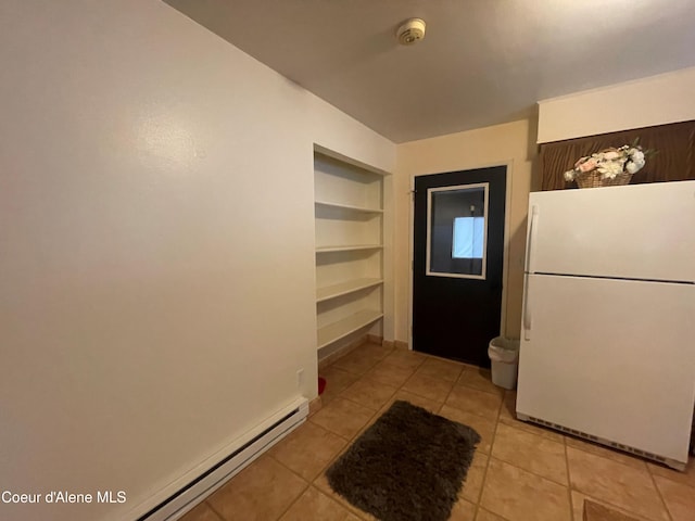 kitchen featuring light tile patterned floors, white fridge, baseboard heating, and built in shelves