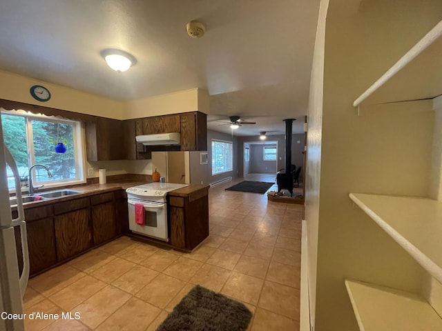 kitchen featuring dark brown cabinets, ceiling fan, sink, light tile patterned floors, and white electric stove