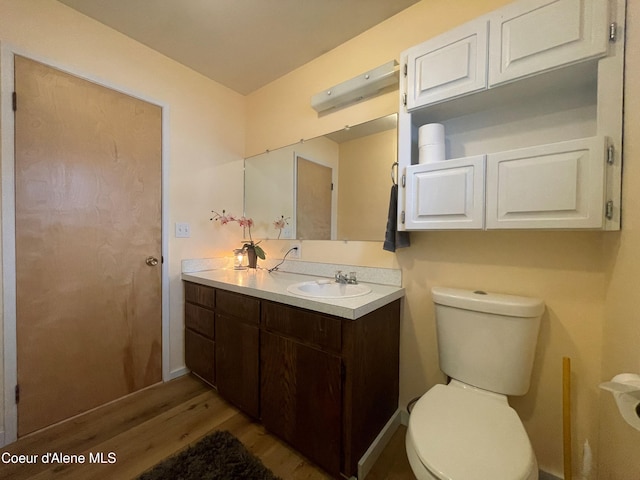 bathroom with vanity, toilet, and wood-type flooring