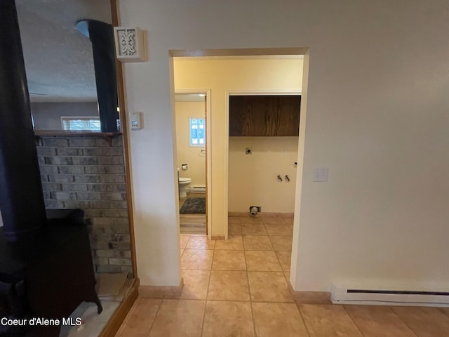hall featuring light tile patterned flooring and a baseboard heating unit