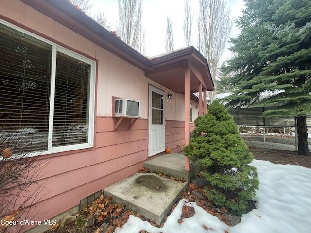 view of snow covered exterior featuring an AC wall unit
