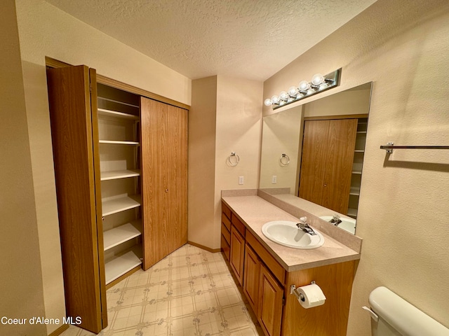 bathroom with vanity, a textured ceiling, and toilet