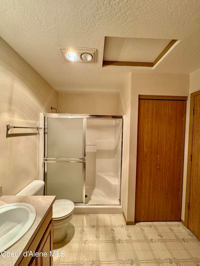 bathroom featuring vanity, a textured ceiling, toilet, and an enclosed shower