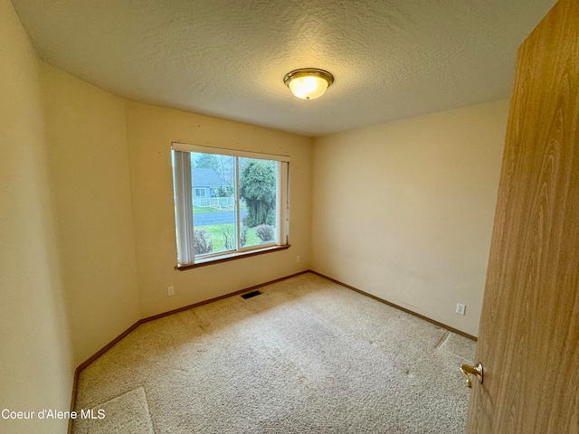 empty room featuring carpet and a textured ceiling