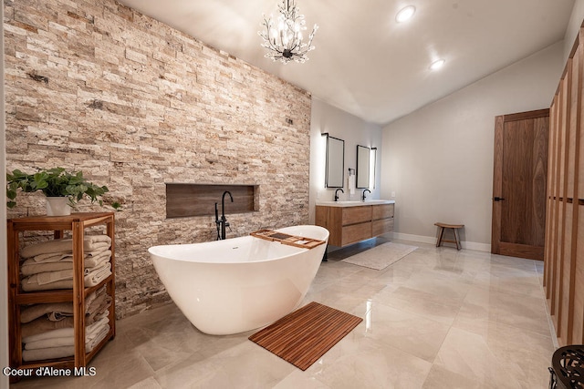 bathroom featuring vanity, a bath, lofted ceiling, and an inviting chandelier