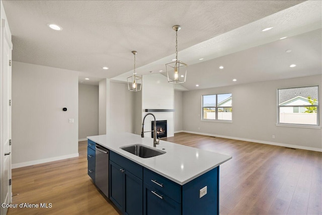 kitchen featuring pendant lighting, a center island with sink, a healthy amount of sunlight, and light hardwood / wood-style floors