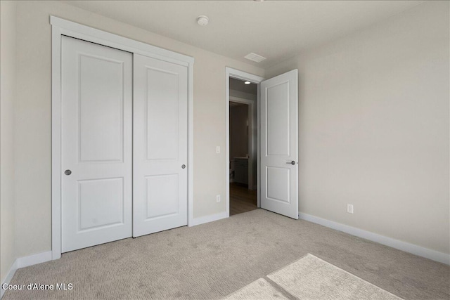 unfurnished bedroom with light carpet and a closet