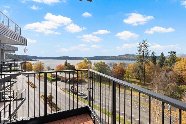 balcony featuring a water and mountain view