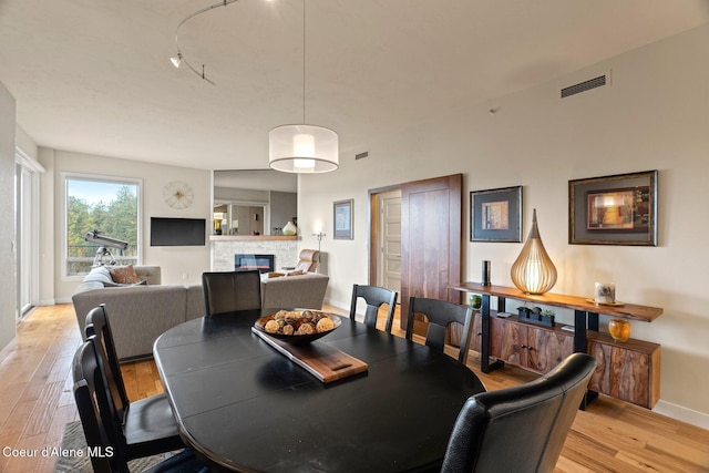 dining space with a fireplace and light hardwood / wood-style floors