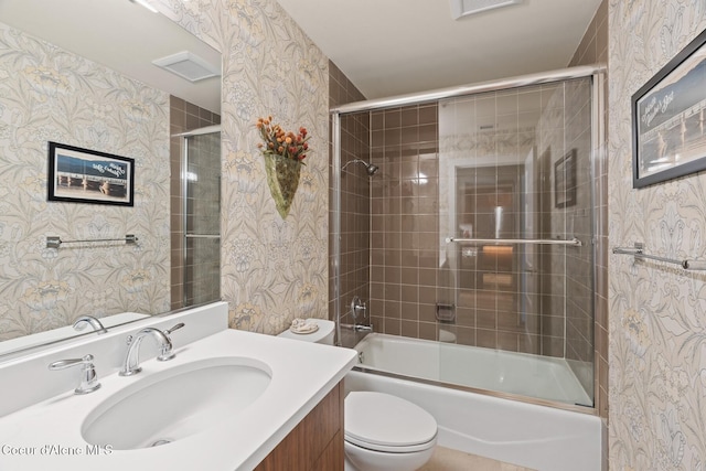 full bathroom featuring combined bath / shower with glass door, toilet, and vanity