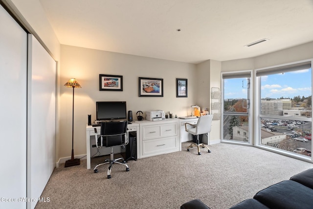 office space featuring built in desk and light carpet