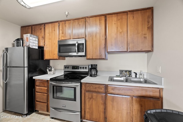 kitchen with light tile patterned flooring, sink, and stainless steel appliances