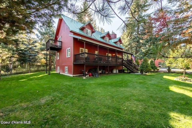 rear view of house featuring a lawn and a balcony