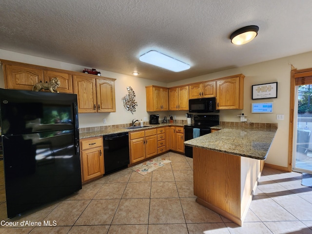 kitchen with black appliances, stone countertops, kitchen peninsula, and light tile patterned floors