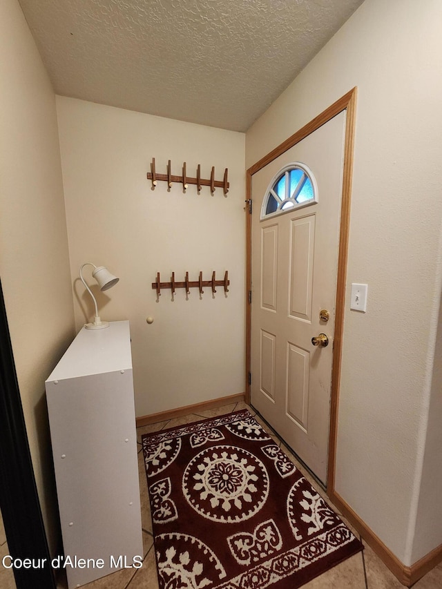 entryway featuring light tile patterned floors and a textured ceiling