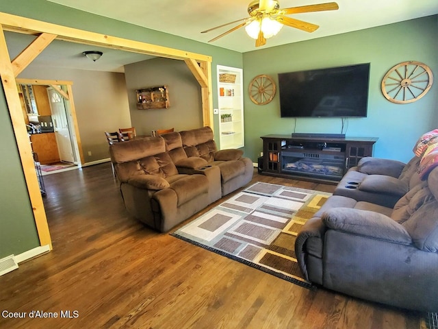 living room with ceiling fan and dark wood-type flooring