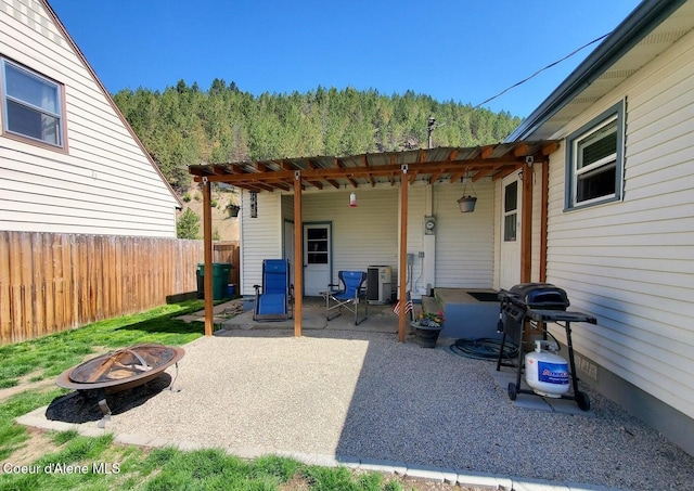 rear view of house with central AC unit, an outdoor fire pit, and a patio area