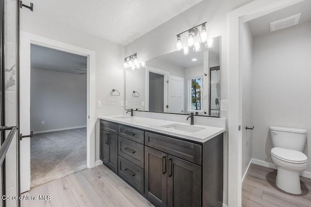 bathroom with wood-type flooring, vanity, and toilet