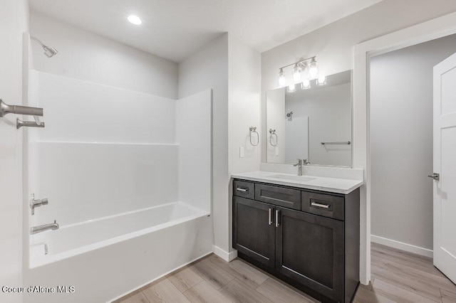 bathroom with hardwood / wood-style floors, vanity, and shower / washtub combination