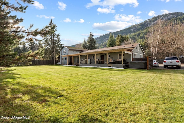 11673 N Boyer Rd, Sandpoint, ID 83864 - back of house featuring a hot tub, a sunroom, and a mountain view