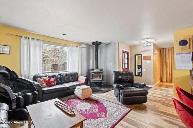 11673 N Boyer Rd, Sandpoint, ID 83864 - living area featuring a wood stove, light wood-style floors, and baseboards