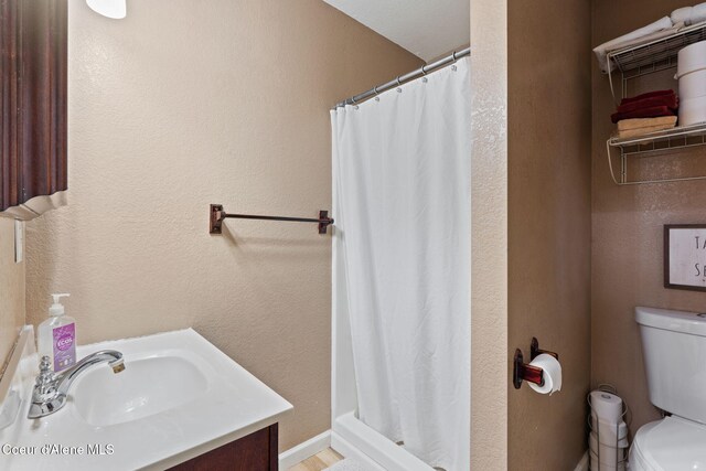 11673 N Boyer Rd, Sandpoint, ID 83864 - bathroom with toilet, vanity, and curtained shower