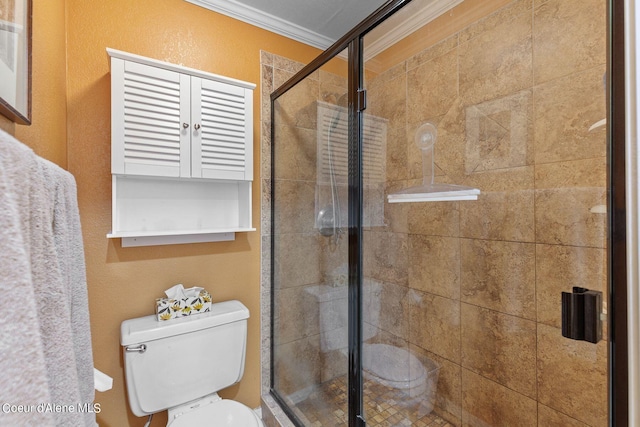 bathroom with toilet, a shower with shower door, and ornamental molding