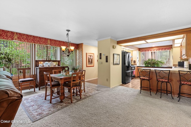 dining room with crown molding, light hardwood / wood-style flooring, and a notable chandelier