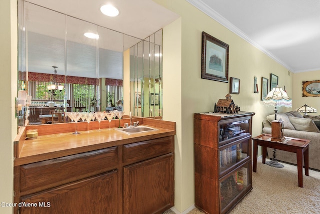 bar with sink, a notable chandelier, pendant lighting, light colored carpet, and ornamental molding