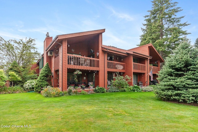 back of house with a lawn, a wall mounted air conditioner, and a balcony