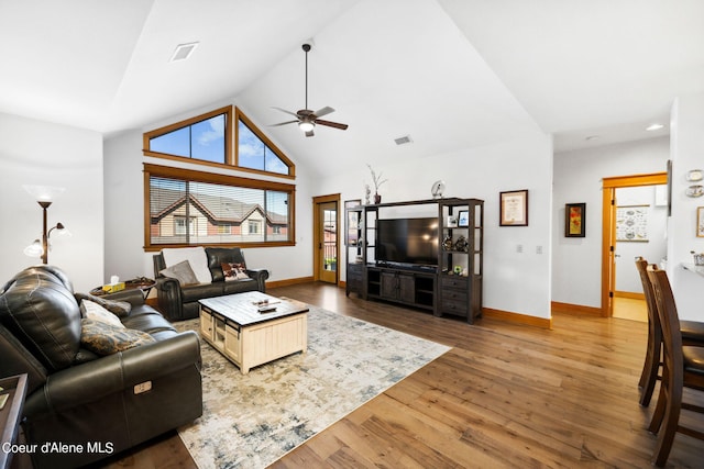 living room with hardwood / wood-style floors, high vaulted ceiling, and ceiling fan