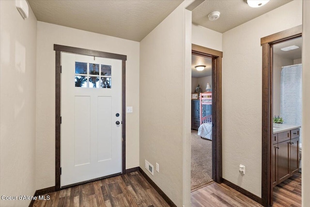 entryway with a textured ceiling and dark hardwood / wood-style floors