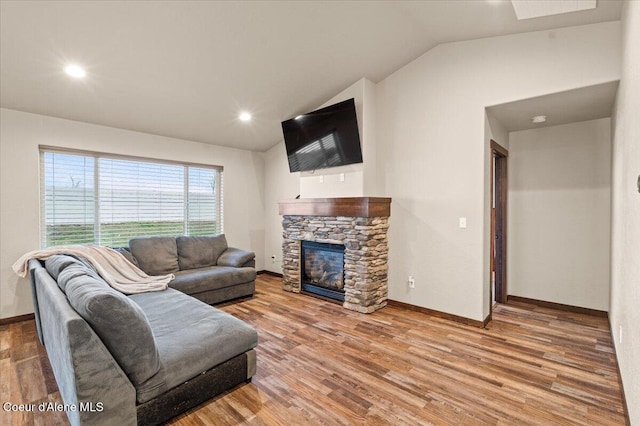 living room featuring hardwood / wood-style flooring, lofted ceiling, and a fireplace