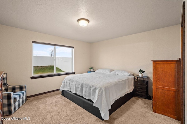 bedroom featuring light colored carpet and a textured ceiling