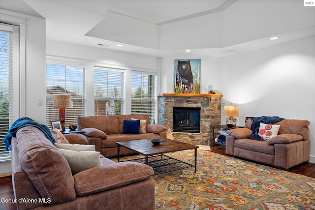 living room with a fireplace, dark wood-type flooring, and a high ceiling