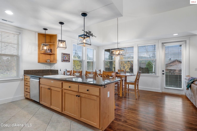 kitchen with kitchen peninsula, light hardwood / wood-style floors, stainless steel dishwasher, and sink