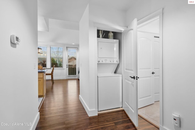 corridor featuring stacked washer and dryer and dark hardwood / wood-style floors