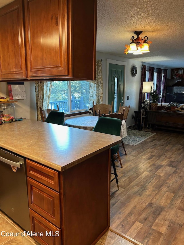 kitchen featuring dishwasher, wood-type flooring, and a textured ceiling