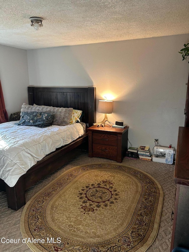 bedroom featuring carpet flooring and a textured ceiling