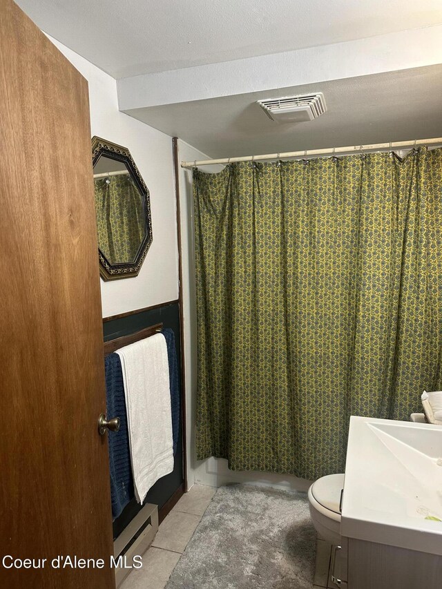 bathroom with walk in shower, tile patterned flooring, vanity, and toilet