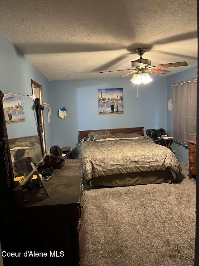 carpeted bedroom with a textured ceiling and ceiling fan