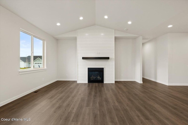 unfurnished living room with a large fireplace, dark hardwood / wood-style floors, and lofted ceiling