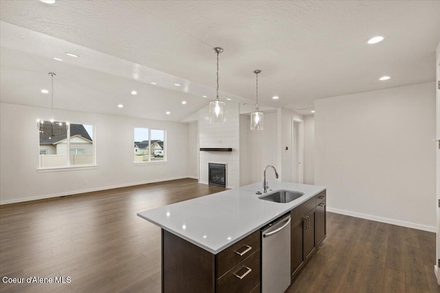 kitchen with sink, hanging light fixtures, stainless steel dishwasher, an island with sink, and lofted ceiling