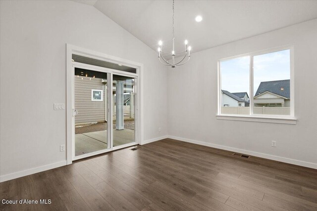 spare room with dark hardwood / wood-style flooring, vaulted ceiling, and an inviting chandelier