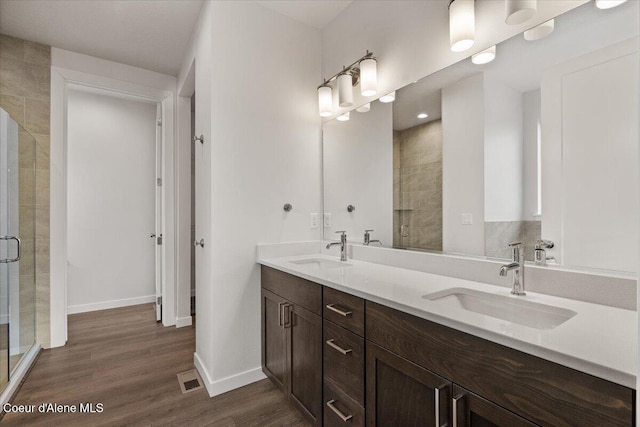 bathroom featuring hardwood / wood-style floors, vanity, and an enclosed shower