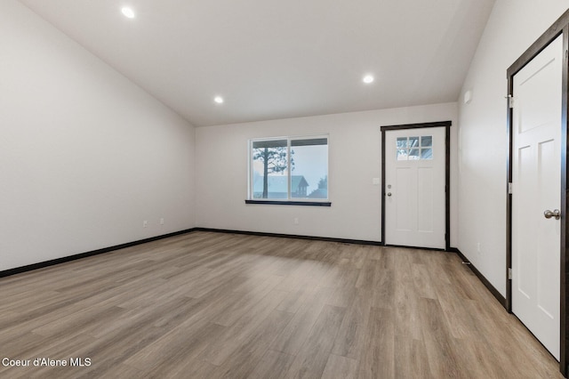 interior space featuring light hardwood / wood-style floors and lofted ceiling